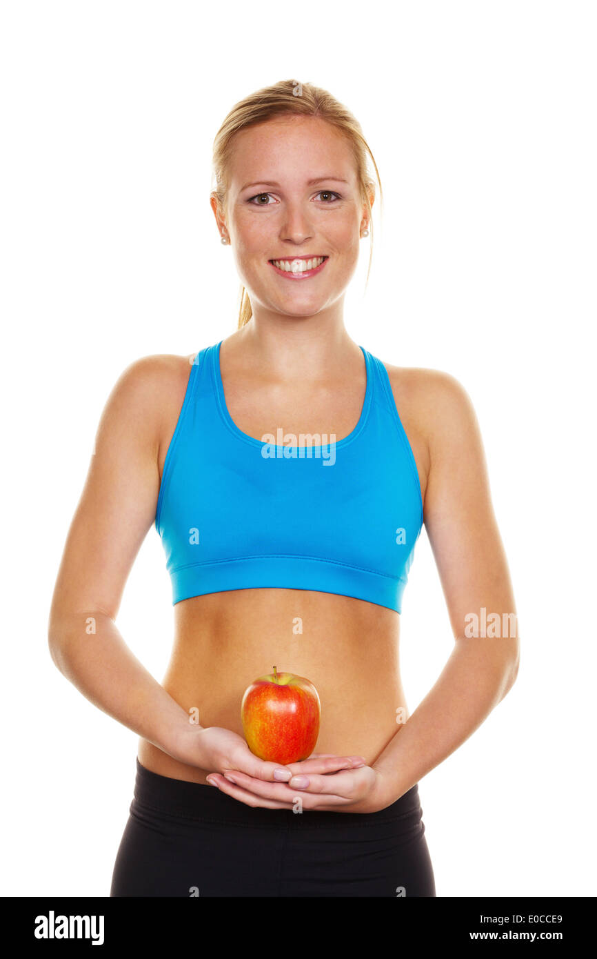Una giovane donna in abbigliamento sportivo detiene un Apple in mano, Eine junge Frau in Sportbekleidung haelt einen Apfel in der mano Foto Stock