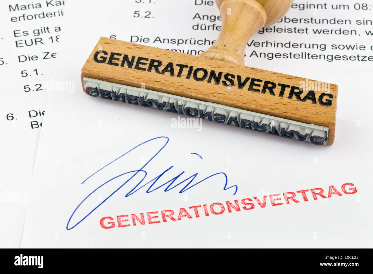 Un francobollo di legno si trova su un documento. Generazione etichetta contratto, Ein Stempel aus Holz liegt auf einem Dokument. Aufschrift grande Foto Stock