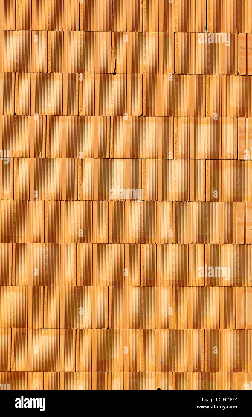 Un nuovo muro di mattoni con un guscio in diretta su un sito di costruzione. Sfondo., Ein neue Ziegelmauer bei einem Rohbau haus auf einer Baustel Foto Stock