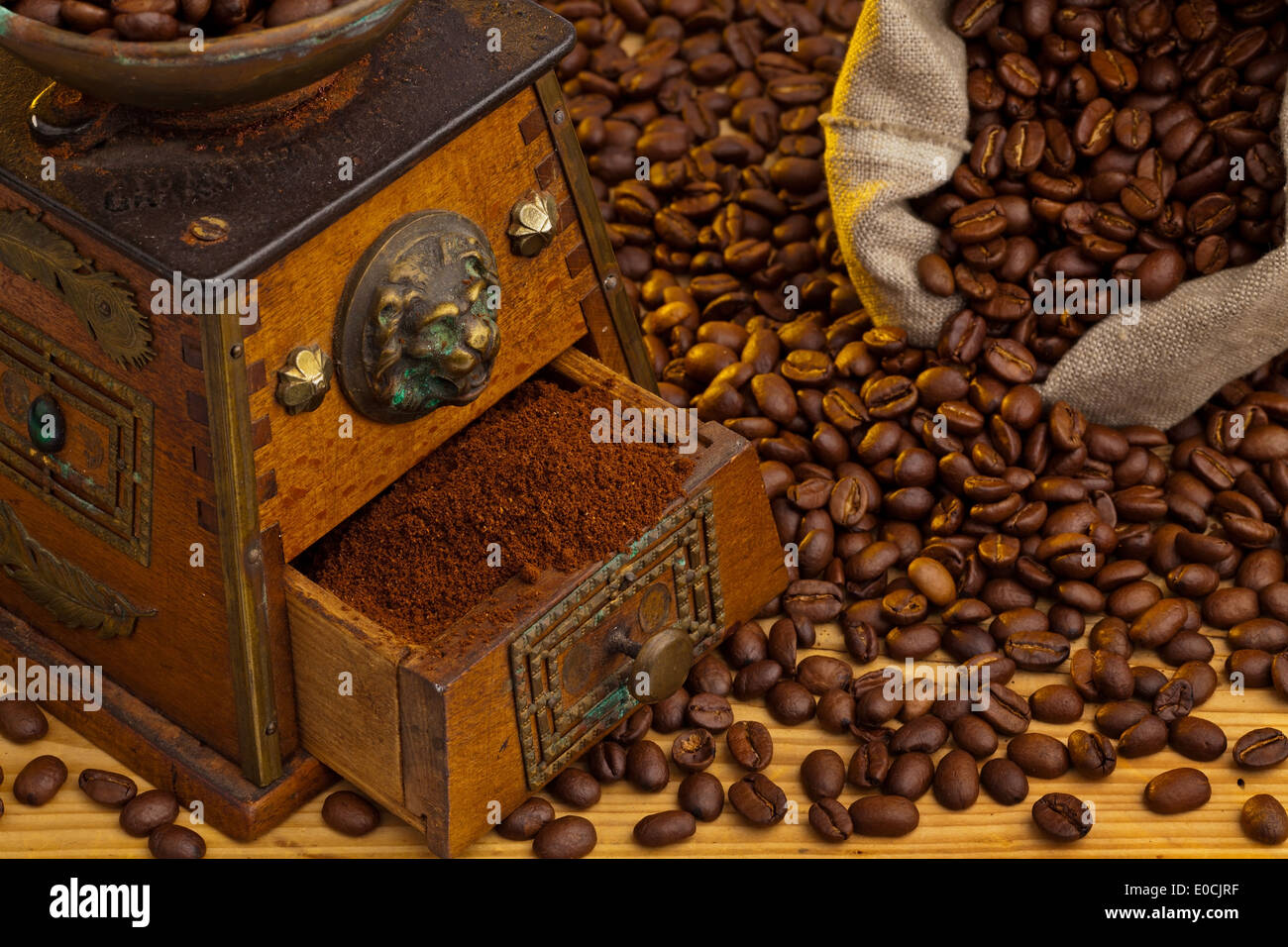 Molti i chicchi di caffè si trovano accanto a coffeegrinder. Foto Stock
