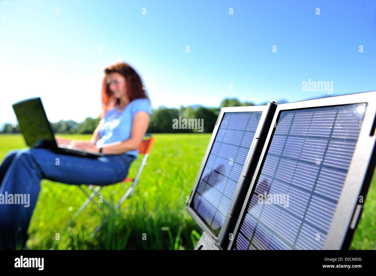 Pannello solare per la produzione di energia elettrica, donna con laptop fuori fuoco in background, Baviera, Germania Foto Stock