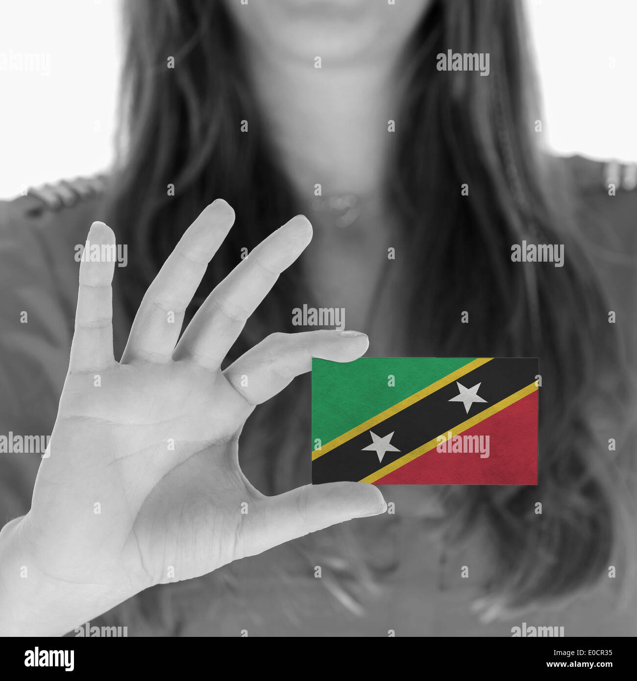 La donna che mostra una carta business bandiera di Saint Kitts e Nevis Foto Stock
