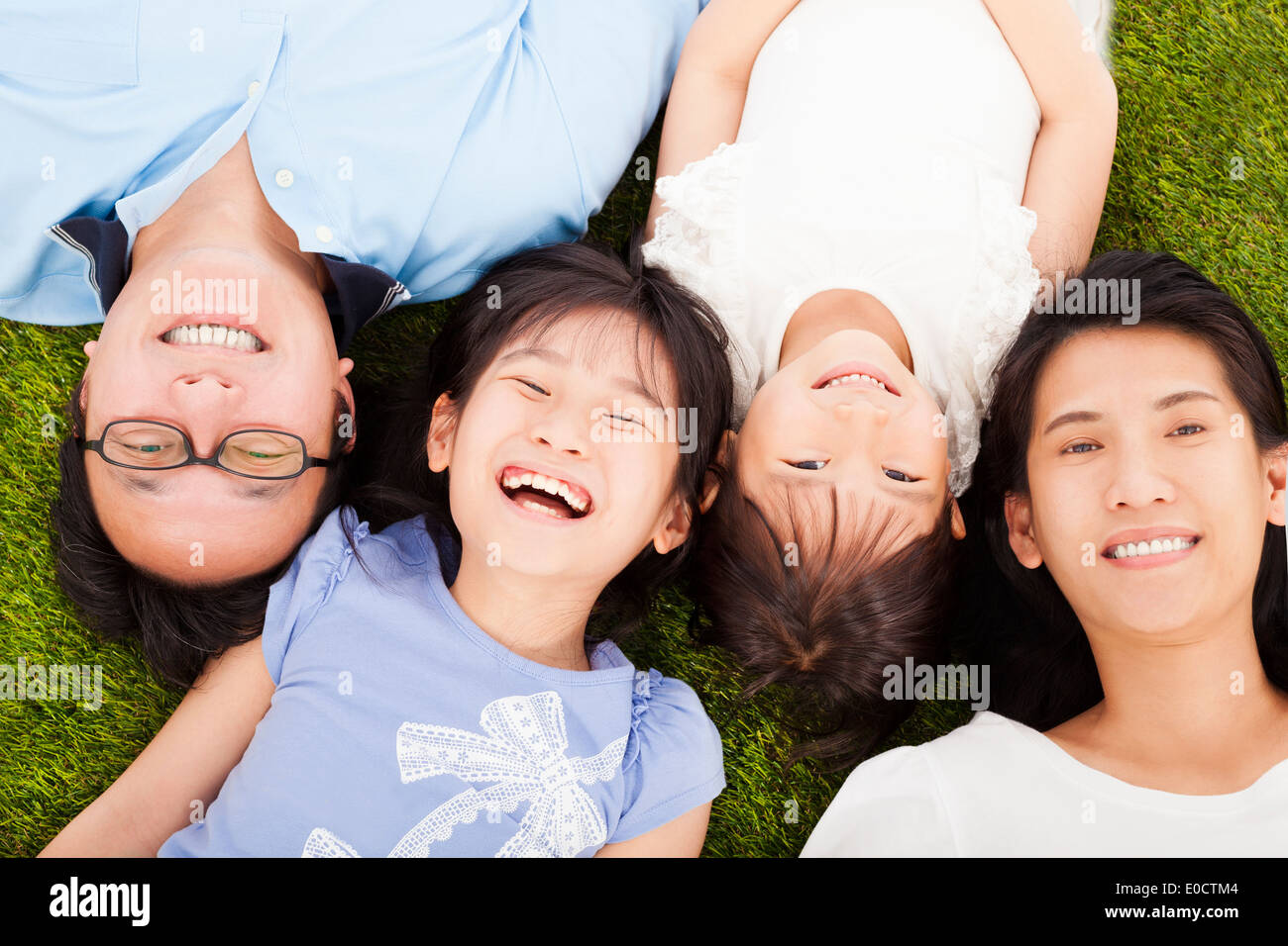 La famiglia felice sdraiato su un prato insieme Foto Stock