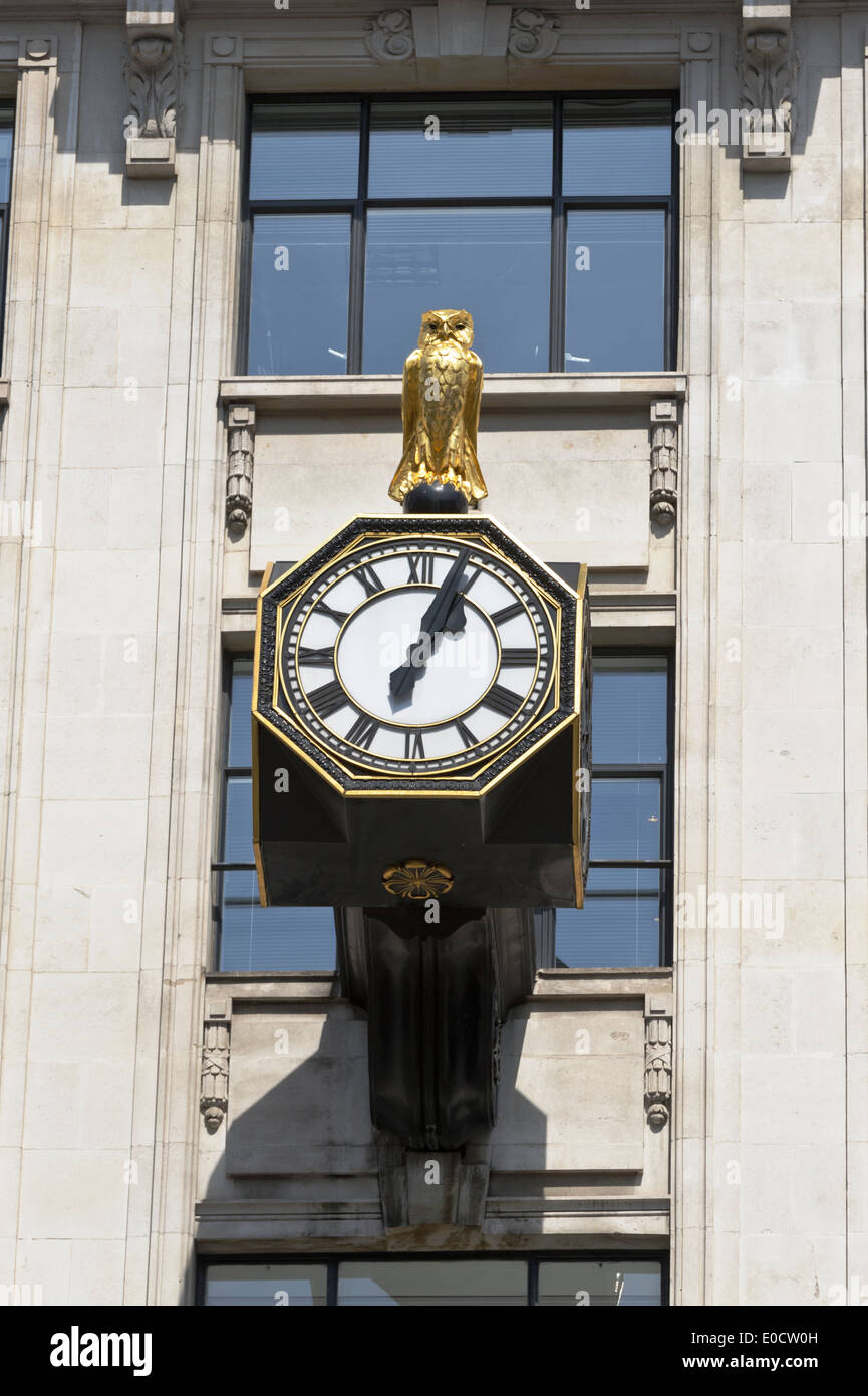 Un gufo reale in cima a tre facce orologio su un edificio vicino il famoso 'Monument', Londra, Inghilterra, Regno Unito. Foto Stock