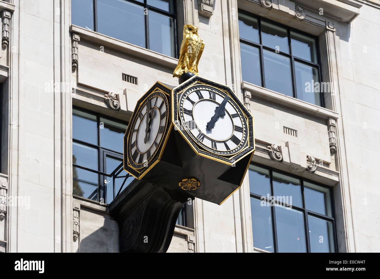 Un gufo reale in cima a tre facce orologio su un edificio vicino il famoso 'Monument', Londra, Inghilterra, Regno Unito. Foto Stock