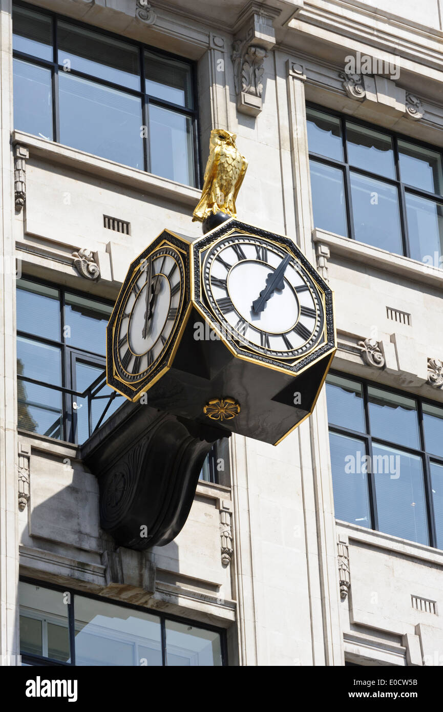 Un gufo reale in cima a tre facce orologio su un edificio vicino il famoso 'Monument', Londra, Inghilterra, Regno Unito. Foto Stock