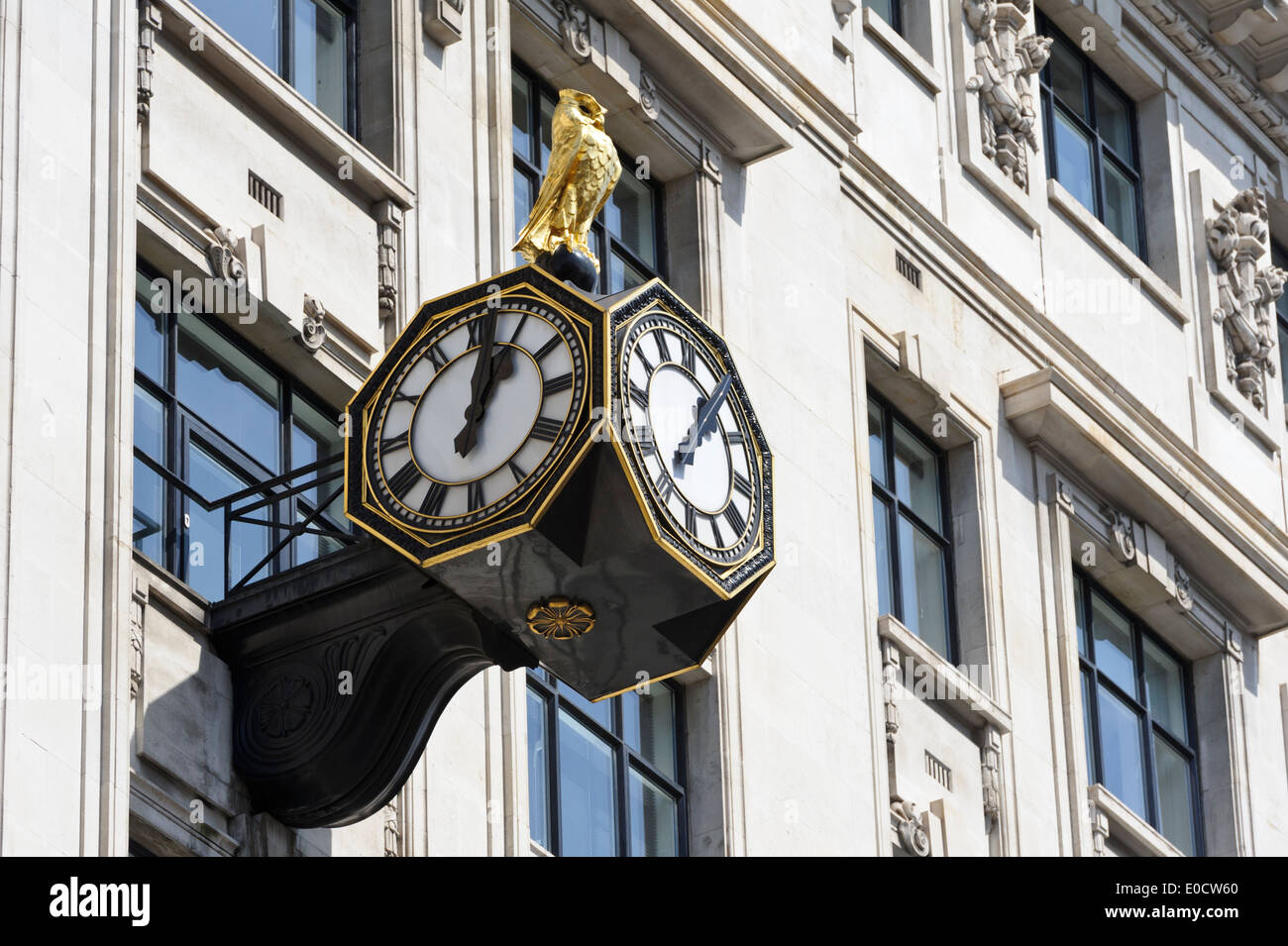 Un gufo reale in cima a tre facce orologio su un edificio vicino il famoso 'Monument', Londra, Inghilterra, Regno Unito. Foto Stock