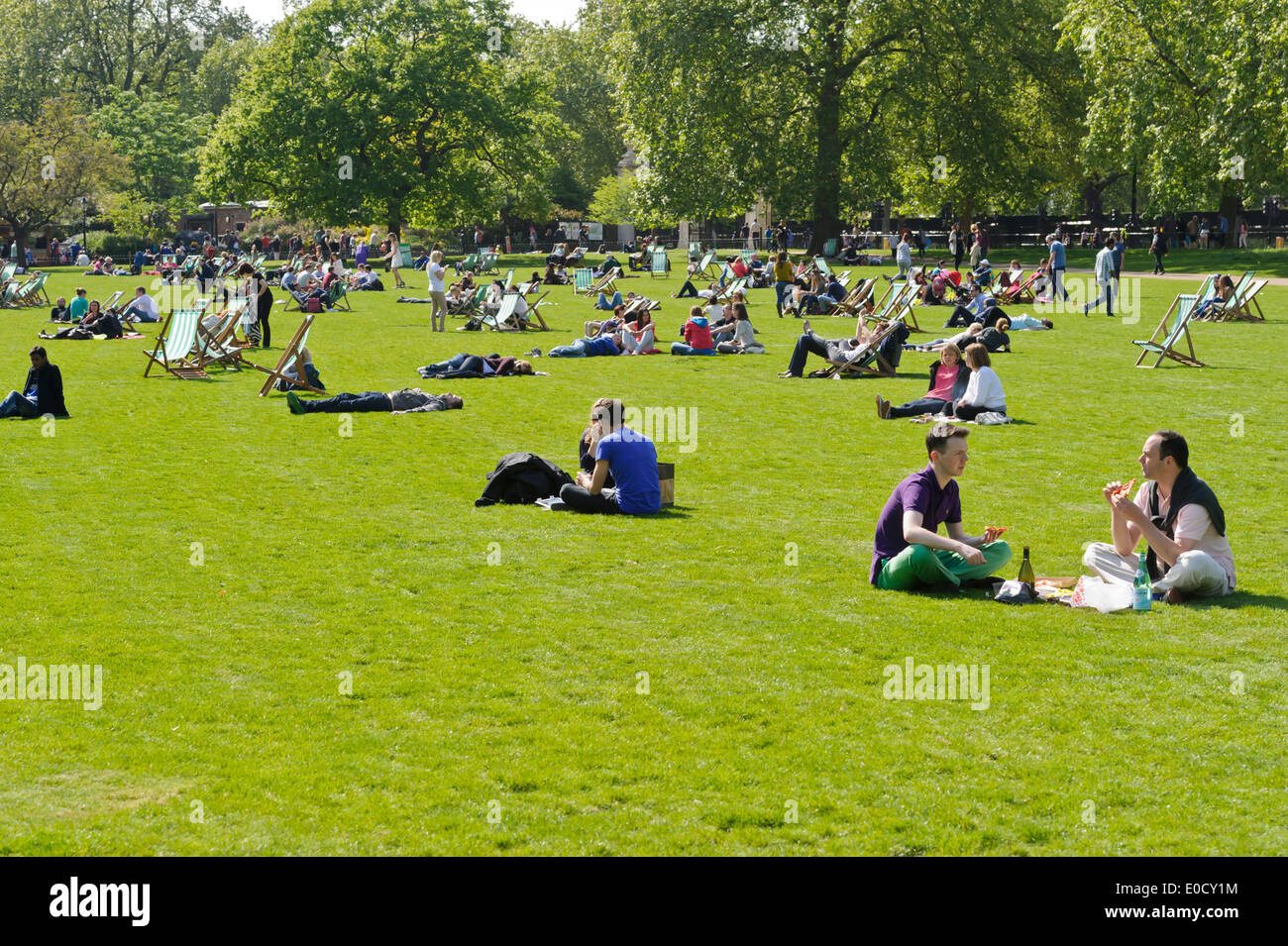 Le persone che si godono il caldo clima britannico nel parco, Londra, Inghilterra, Regno Unito. Foto Stock