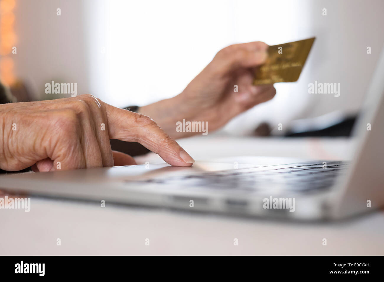 Femmina matura laptop closeup mani carta plastica shop interni Foto Stock