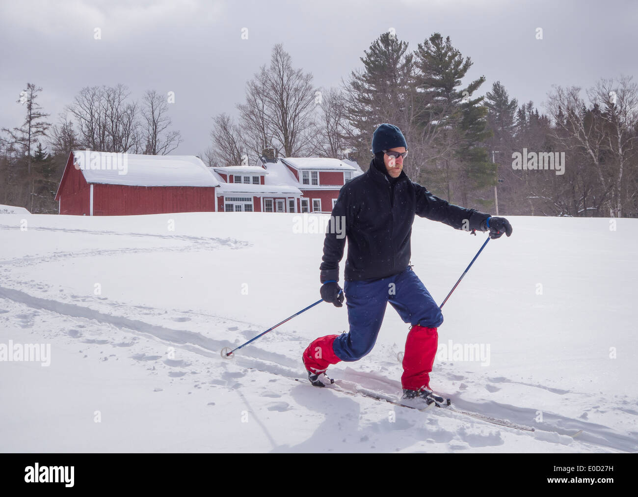 WARREN, Vermont, USA - Uomo sci di fondo nella parte anteriore del casale. Foto Stock