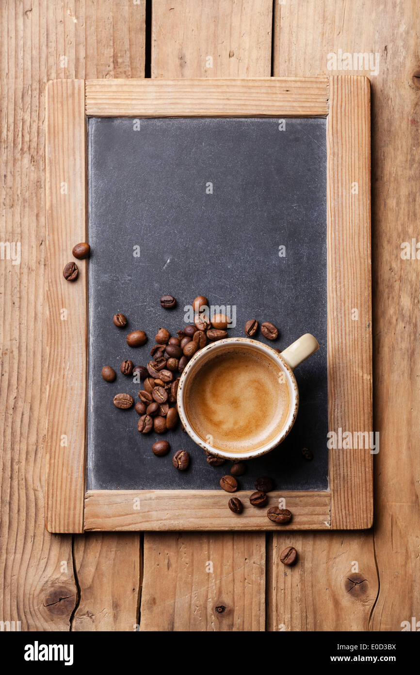 Tazza di caffè con i chicchi di caffè su ardesia vintage chalk board Foto Stock