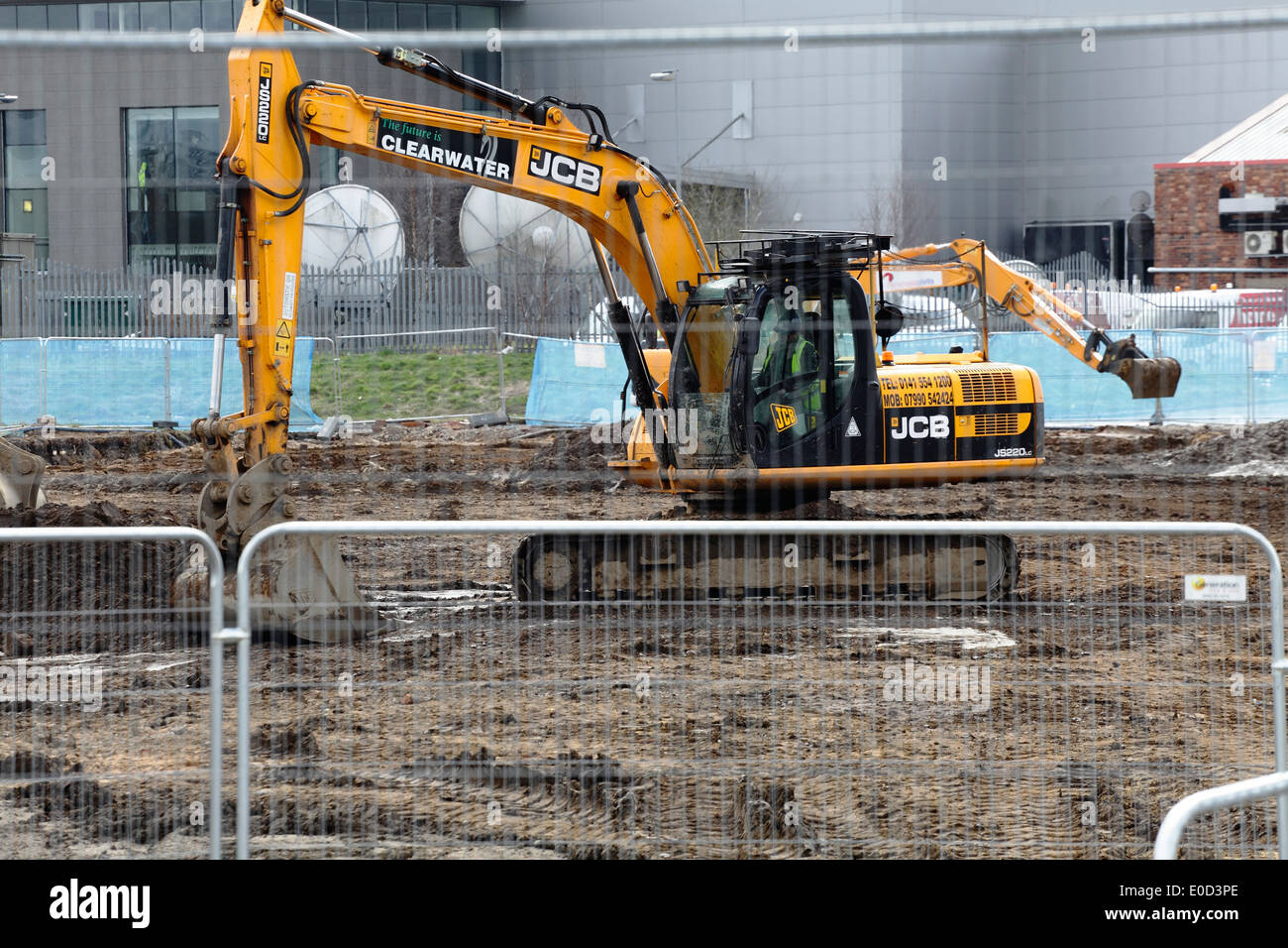 Scavatrice meccanica JCB che scavava terra in un cantiere, Scozia, Regno Unito Foto Stock