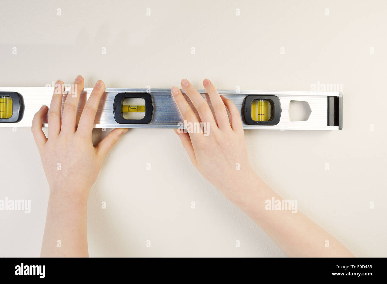 Foto orizzontale di mani femminili a livello di contenimento contro interno home muro bianco Foto Stock