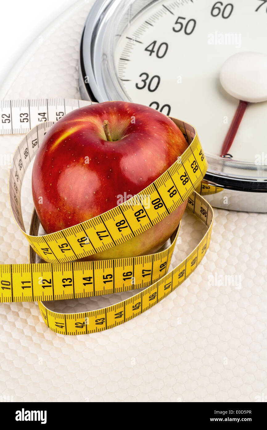 Sulle scale di personale si trova un apple. Foto simbolico per diminuire e sani di alta vitamina cibo., auf einer Personenwaage l Foto Stock