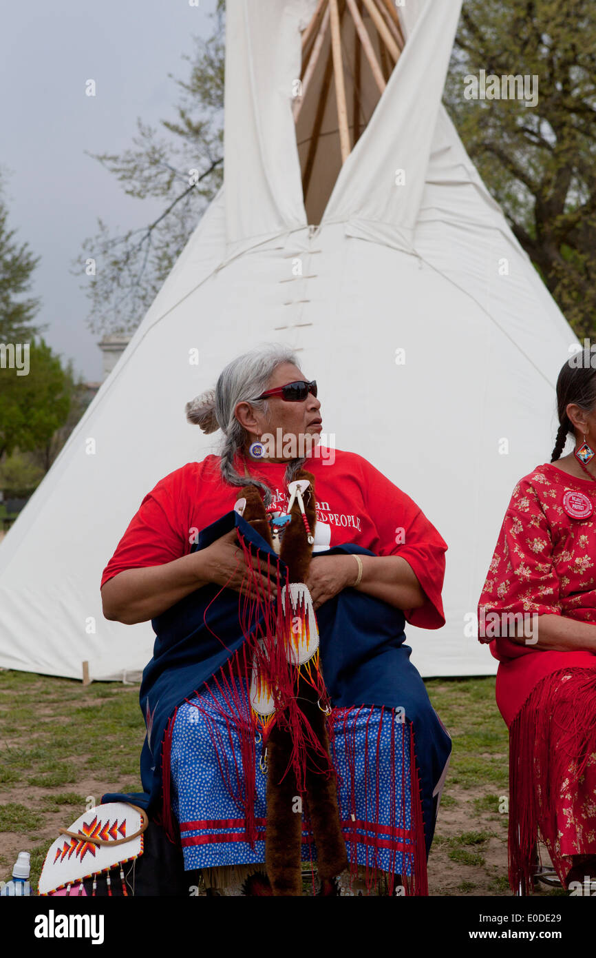 Anziani Native-American donna seduta davanti a un tende Tepee Foto Stock