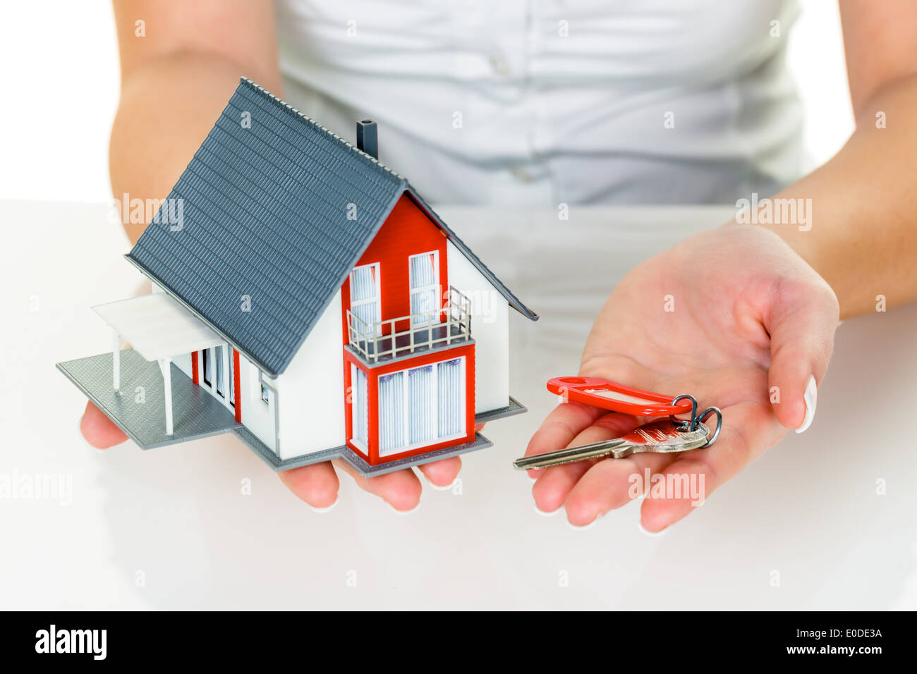 Un broker per immobili con una casa e una chiave. Il successo di noleggio e vendita di case da agenti immobiliari., Ein Makler fuer Immobilie Foto Stock