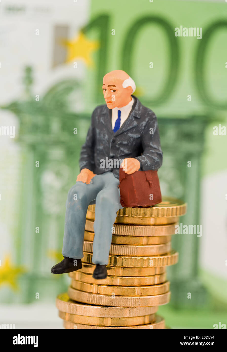 Titolare di una pensione o di una rendita si siede su una pila di monete. Foto simbolico per pensioni e Penison, Ein Rentner sitzt auf einem Muenzstapel. Symbolfoto fue Foto Stock