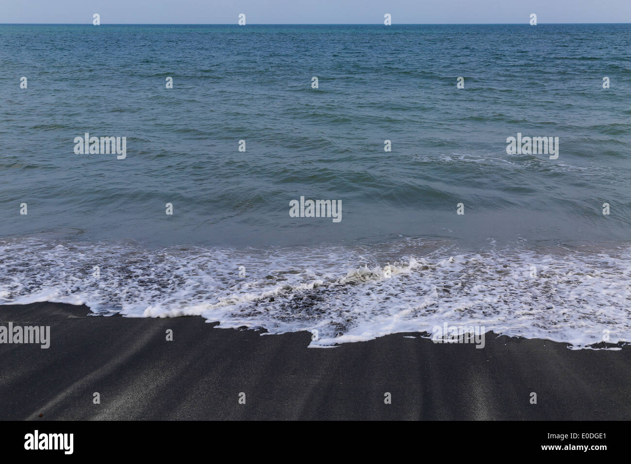 Nero di spiaggia di sabbia nera Repubblica di Panama sabbia acqua di mare orizzonte blu cielo Foto Stock