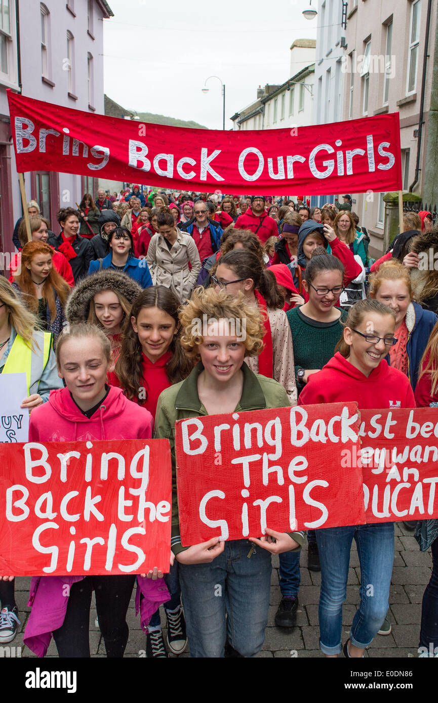 Aberystwyth, Wales UK, sabato 10 maggio 2014 centinaia di ragazze e donne di tutte le età e tutti indossano rosso, hanno marciato per le strade di Aberystwyth Sabato 10 Maggio 2014 a sostegno dell'assenza di ragazze adolescenti rapiti da Boko Haram estremisti islamici in Nigeria. Azienda fatti a mano i segni hanno elaborato dalla città orologio attraverso il castello e si è conclusa sul lungomare. Credito: keith morris/Alamy Live News Foto Stock