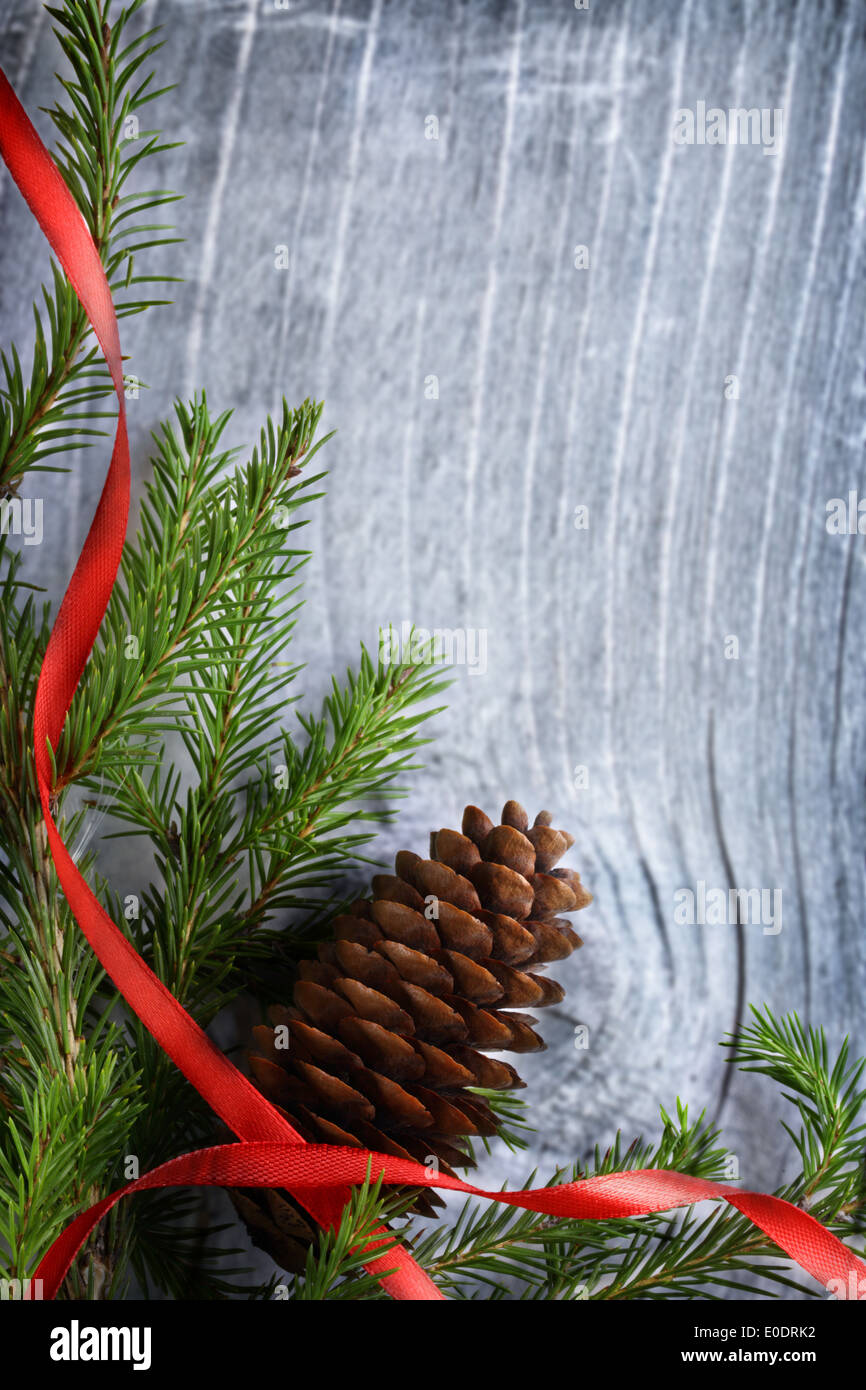 Decorazione di natale con abeti e cono su sfondo di legno Foto Stock