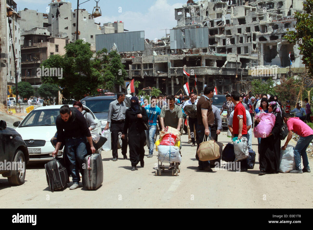 Homs, sabato. Il 10 maggio, 2014. I residenti portano i loro averi in al-Hamidieh quartiere nella parte vecchia della città di Homs, Siria, Sabato 10 Maggio, 2014. Il governatore della Siria La provincia centrale di Homs Talal Barazi venerdì ha dichiarato la città vecchia di Homs sicuro e svuotare di armi e ribelli armati, dopo l'evacuazione dell'ultimo lotto di ribelli vi, il funzionario SANA News Agency. Credito: Bassem Tellawi/Xinhua/Alamy Live News Foto Stock