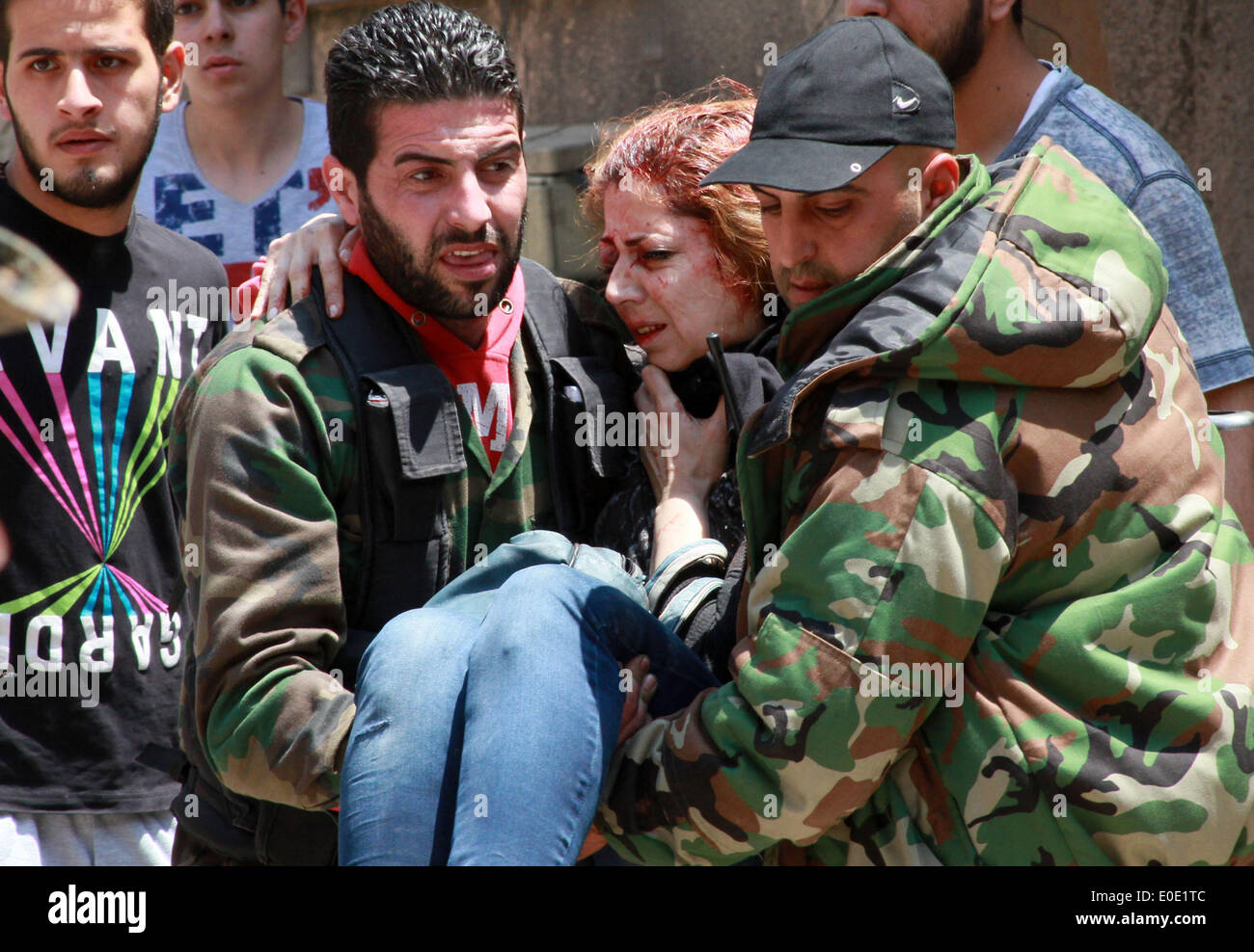 Homs, sabato. Il 10 maggio, 2014. Trasferimenti di persone una donna, che è stato ferito da una mina che è andato via in m Bustan Al-Diwan quartiere nella parte vecchia della città di Homs, Siria, Sabato 10 Maggio, 2014. Secondo i resoconti dei mass media, tre persone sono state ferite dal blast. Il governatore della Siria La provincia centrale di Homs Talal Barazi venerdì ha dichiarato la città vecchia di Homs sicuro e svuotare di armi e ribelli armati, dopo l'evacuazione dell'ultimo lotto di ribelli vi, il funzionario SANA News Agency. Credito: Bassem Tellawi/Xinhua/Alamy Live News Foto Stock