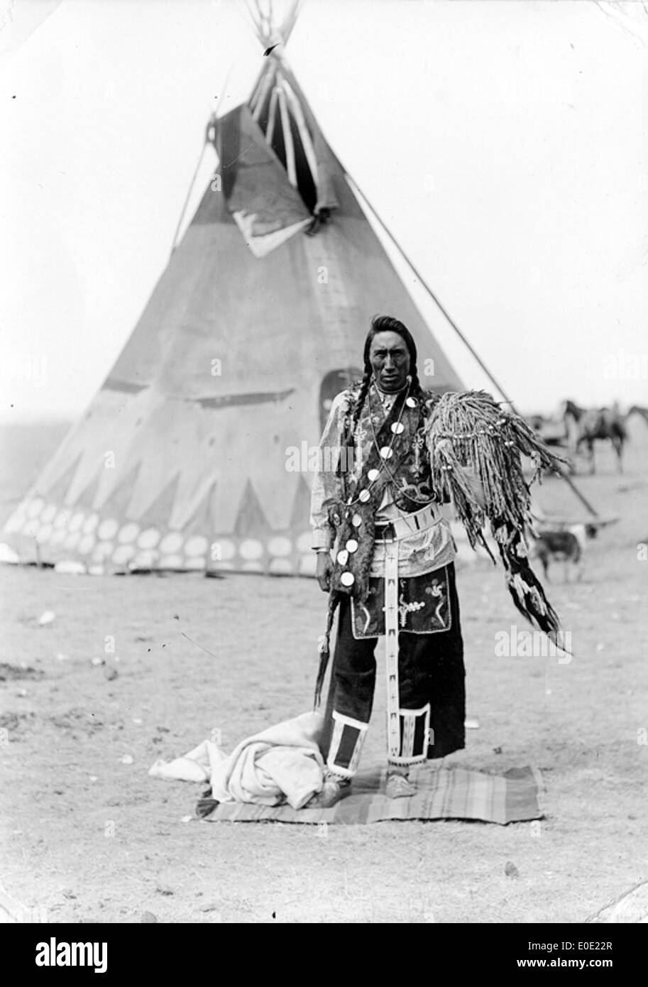 Un uomo della medicina della tribù di sangue in piedi di fronte a un teepee Foto Stock