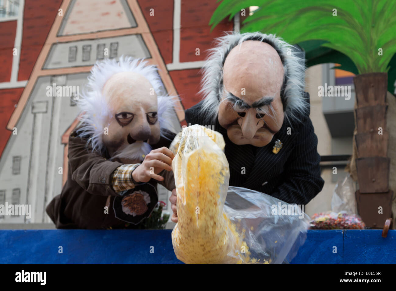 Una fotografia di alcune persone vestite come gli uomini vecchi gettando coriandoli a carnevale in Europa. Foto Stock