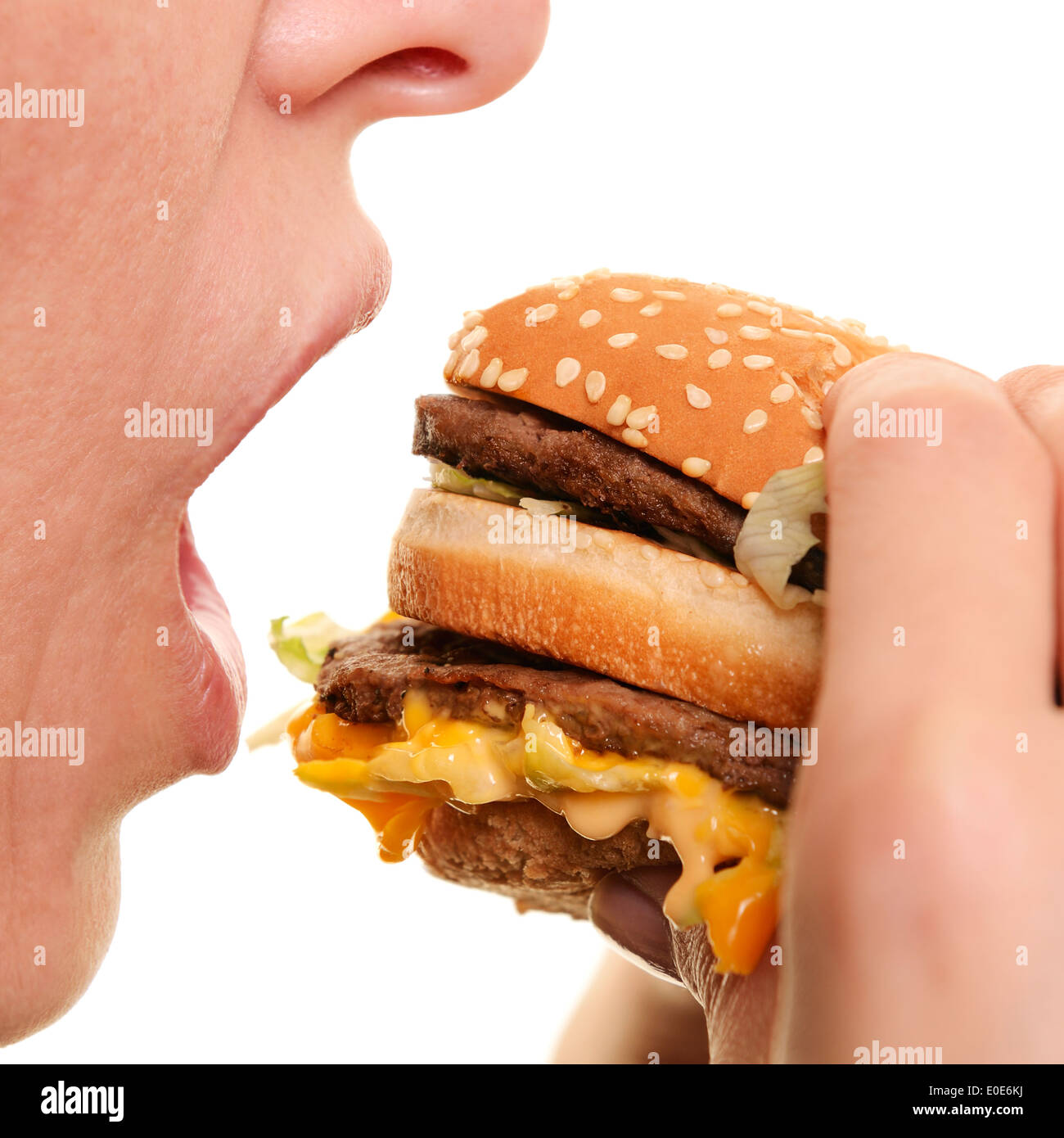 Donna di mangiare un hamburger, vicino. Foto Stock