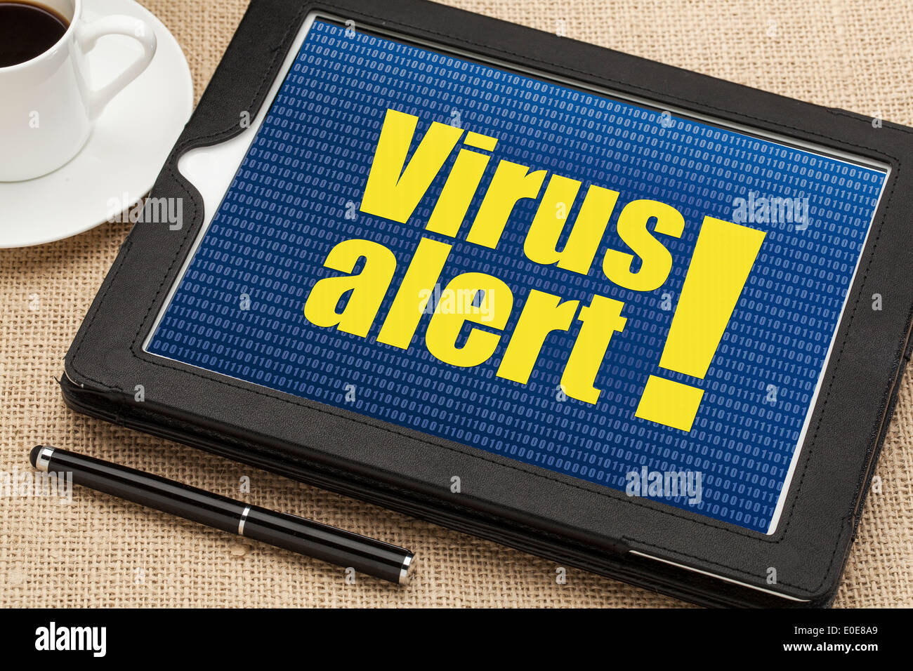Allarme virus su un tablet diigital con una tazza di caffè Foto Stock
