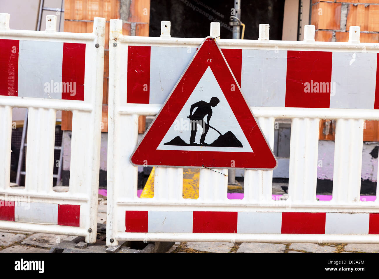 La sicurezza della strada con un edificio sito. Segno con il lavoratore edile, Absicherung der Strasse bei einer Baustelle. Schild Foto Stock