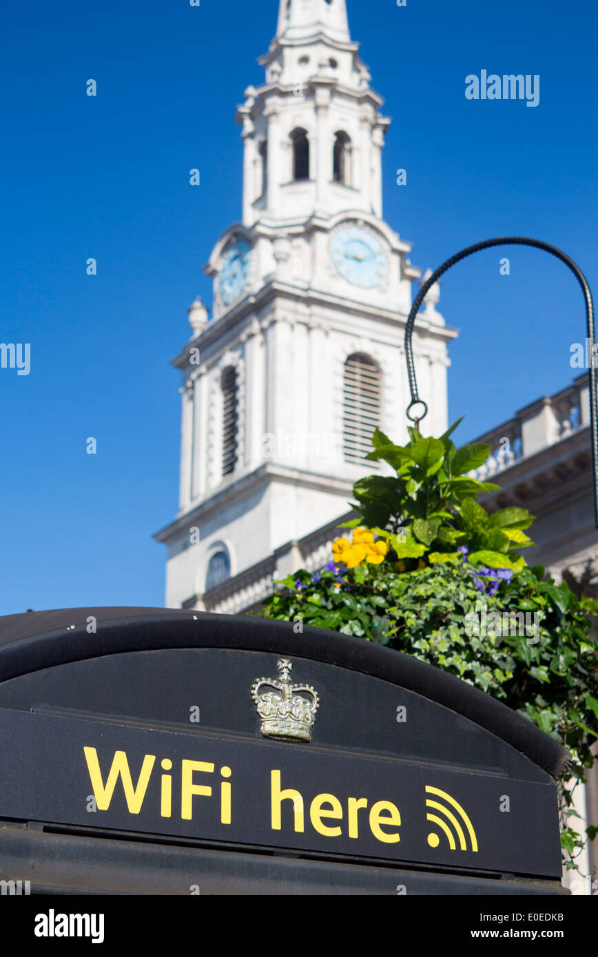 Wifi segno qui su nero telefono BT box con la torre di San Martino nei campi chiesa dietro a Londra England Regno Unito Foto Stock