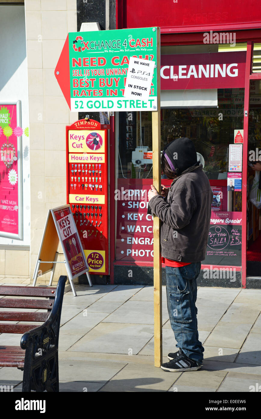 Adolescente di sesso maschile azienda pubblicità segno, il drappeggio, Northampton, Northamptonshire, England, Regno Unito Foto Stock