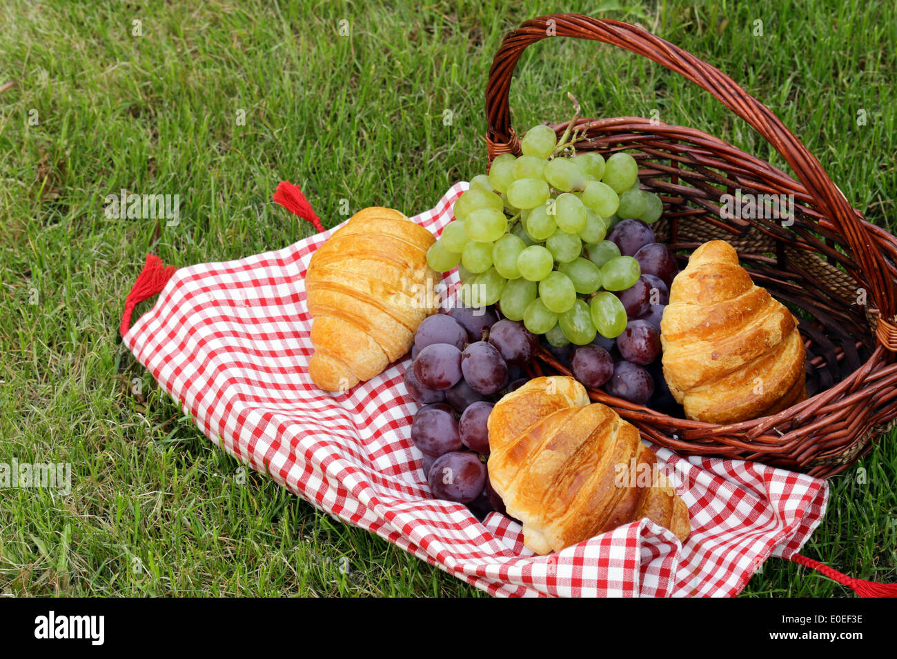 Pic nic sul prato verde con uve e croissant Foto Stock