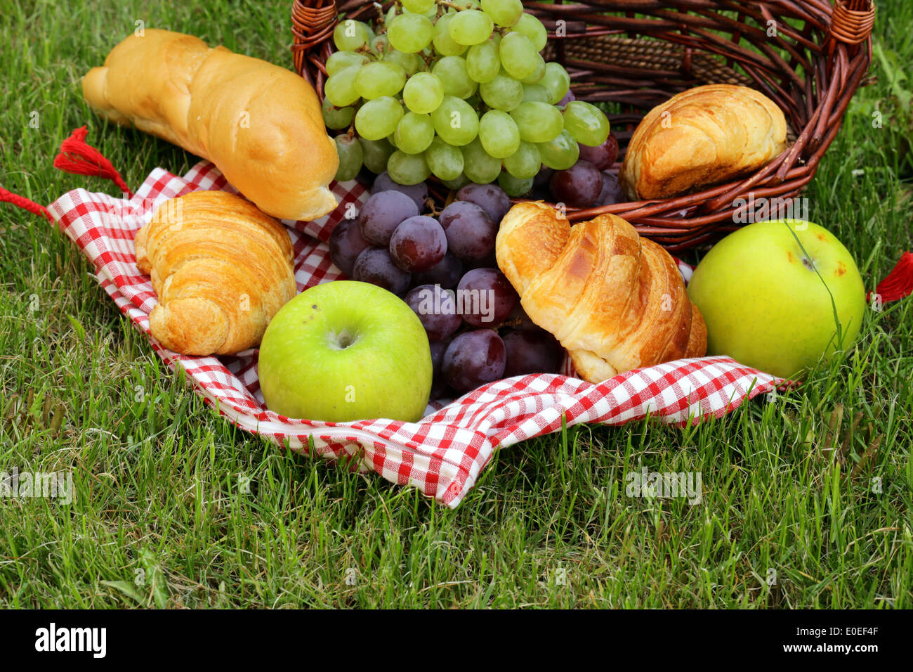 Pic nic sul prato verde con uve e croissant Foto Stock