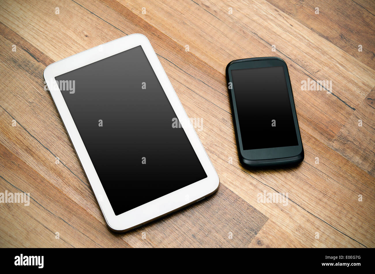 Telefono cellulare e tablet con display vuoto od sfondo di legno Foto Stock