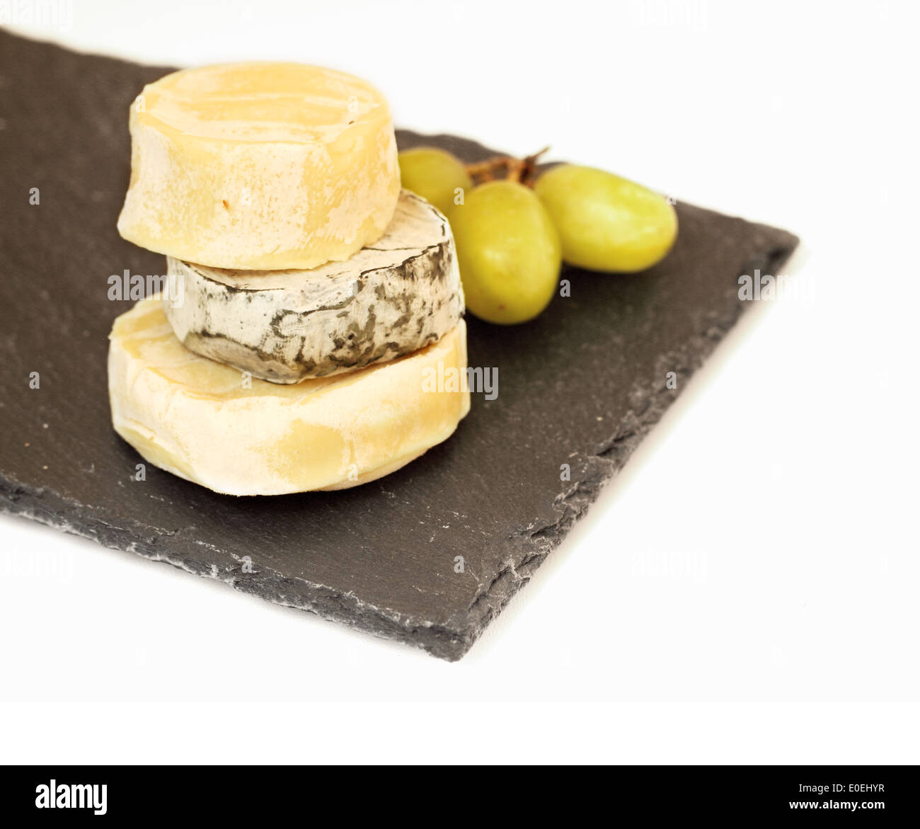 Pila di formaggio camembert e uva sulla lastra di pietra Foto Stock