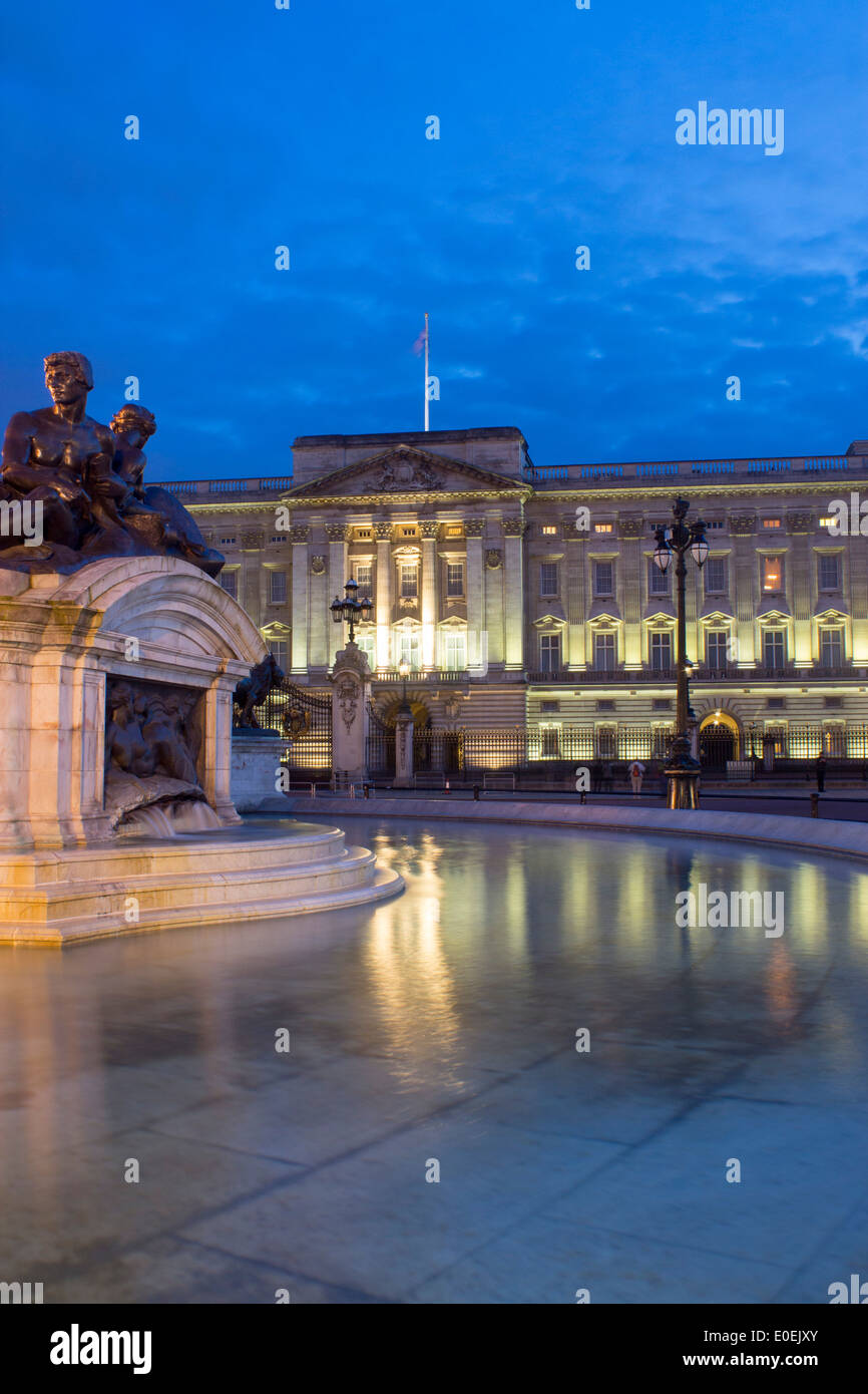 Buckingham Palace di notte con il Victoria Memorial statue riflessa nell'acqua della fontana Londra Inghilterra REGNO UNITO Foto Stock