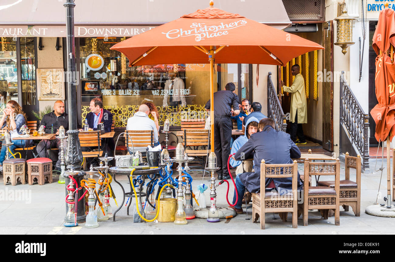 Una vista esterna del ristorante Ayoush, narghilè tubi e le persone sedute a tavoli esterni, James Street Londra Inghilterra REGNO UNITO Foto Stock