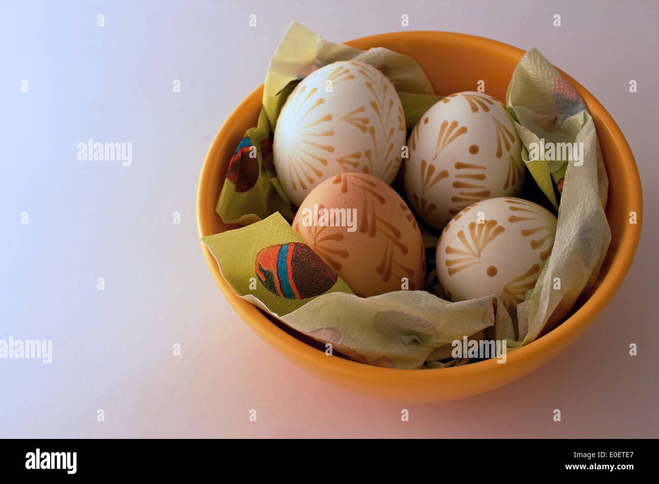 Quattro uova di pasqua nel piatto arancione Foto Stock