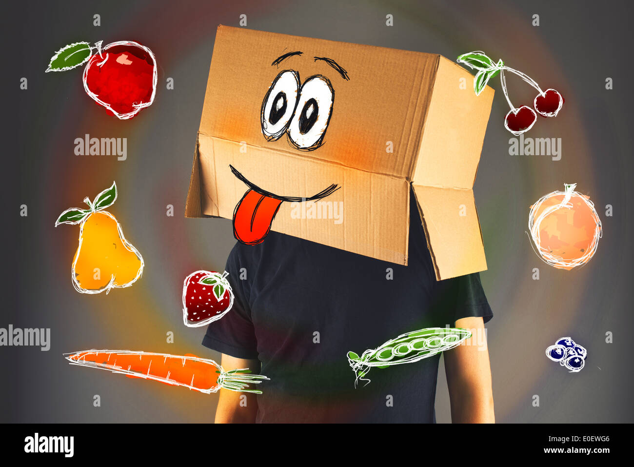 Uomo con scatola di cartone sulla sua testa e gradita espressione faccia guardando doodle disegni di frutta e verdura Foto Stock