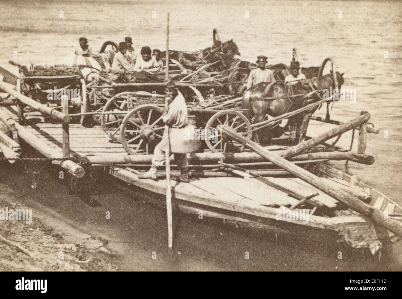 Un traghetto caricato con le persone e i carri su un fiume russo 1880 Foto Stock