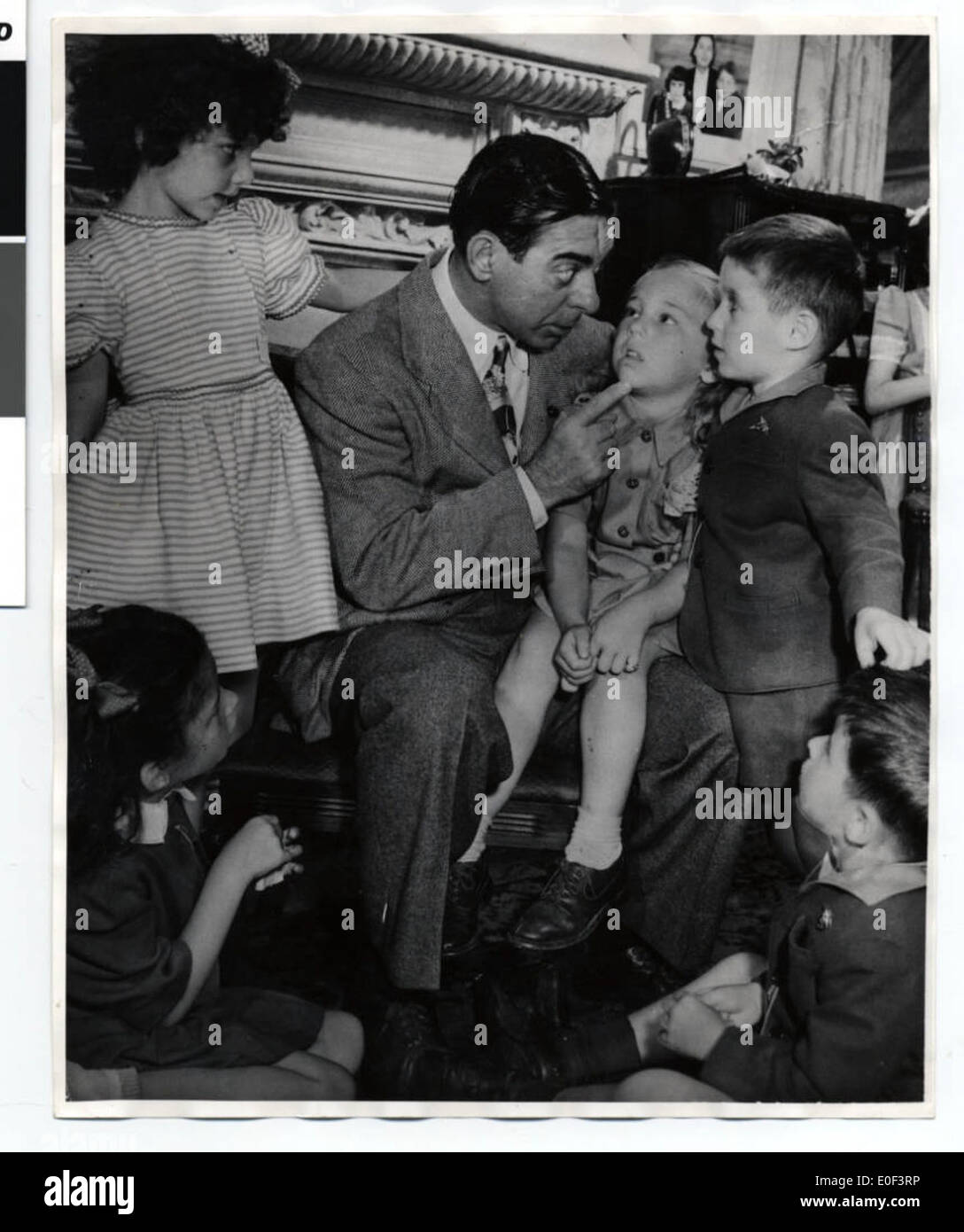 Questa fotografia mostra l'intrattenitore Eddie Cantor con i bambini durante la sua visita a Minneapolis per promuovere l'acquisto di obbligazioni di guerra durante la seconda guerra mondiale. Cantor, una figura popolare, ha sostenuto lo sforzo bellico con apparizioni pubbliche. Foto Stock