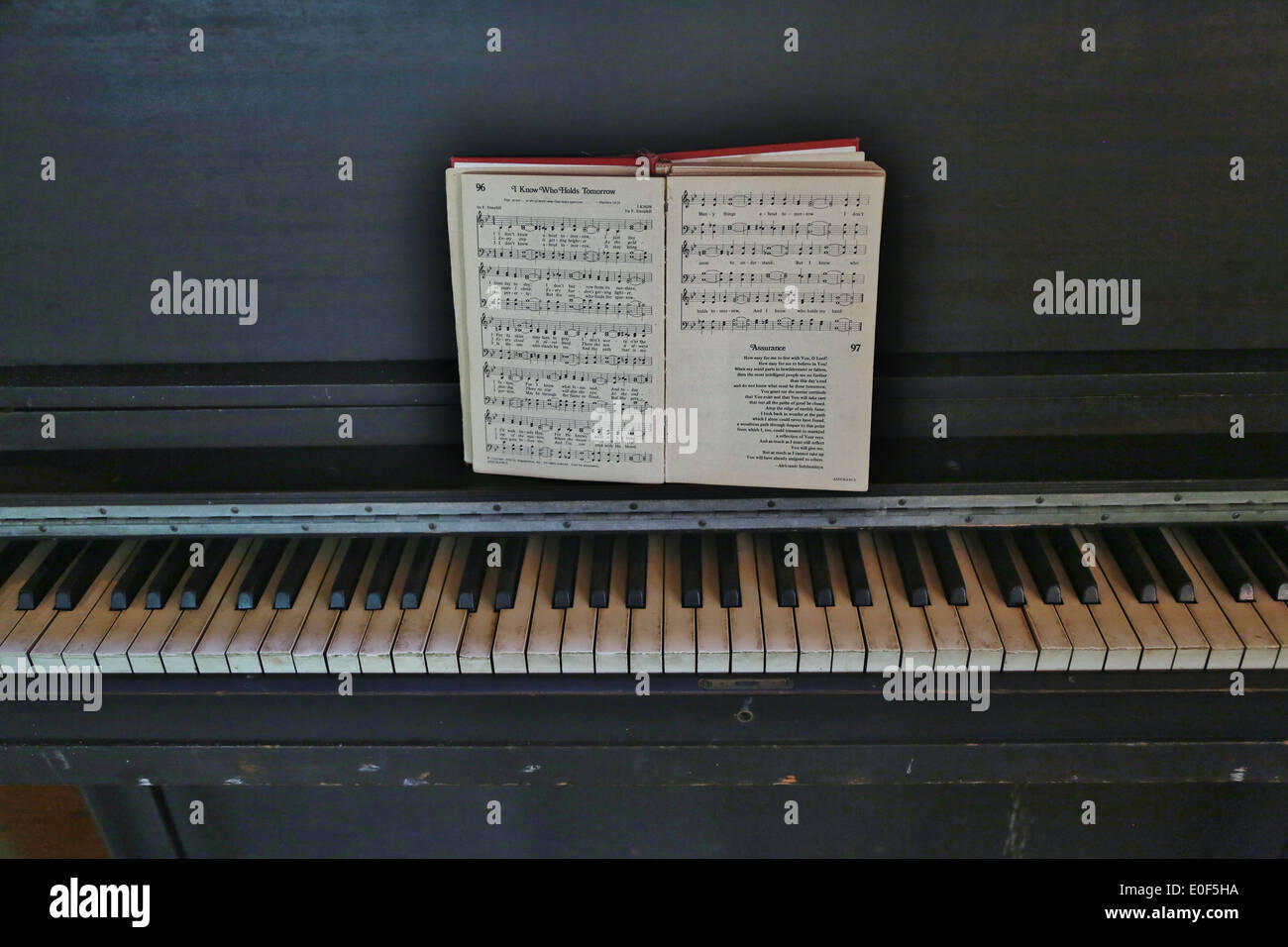 Un antico pianoforte con un inno aperto libro. Foto Stock