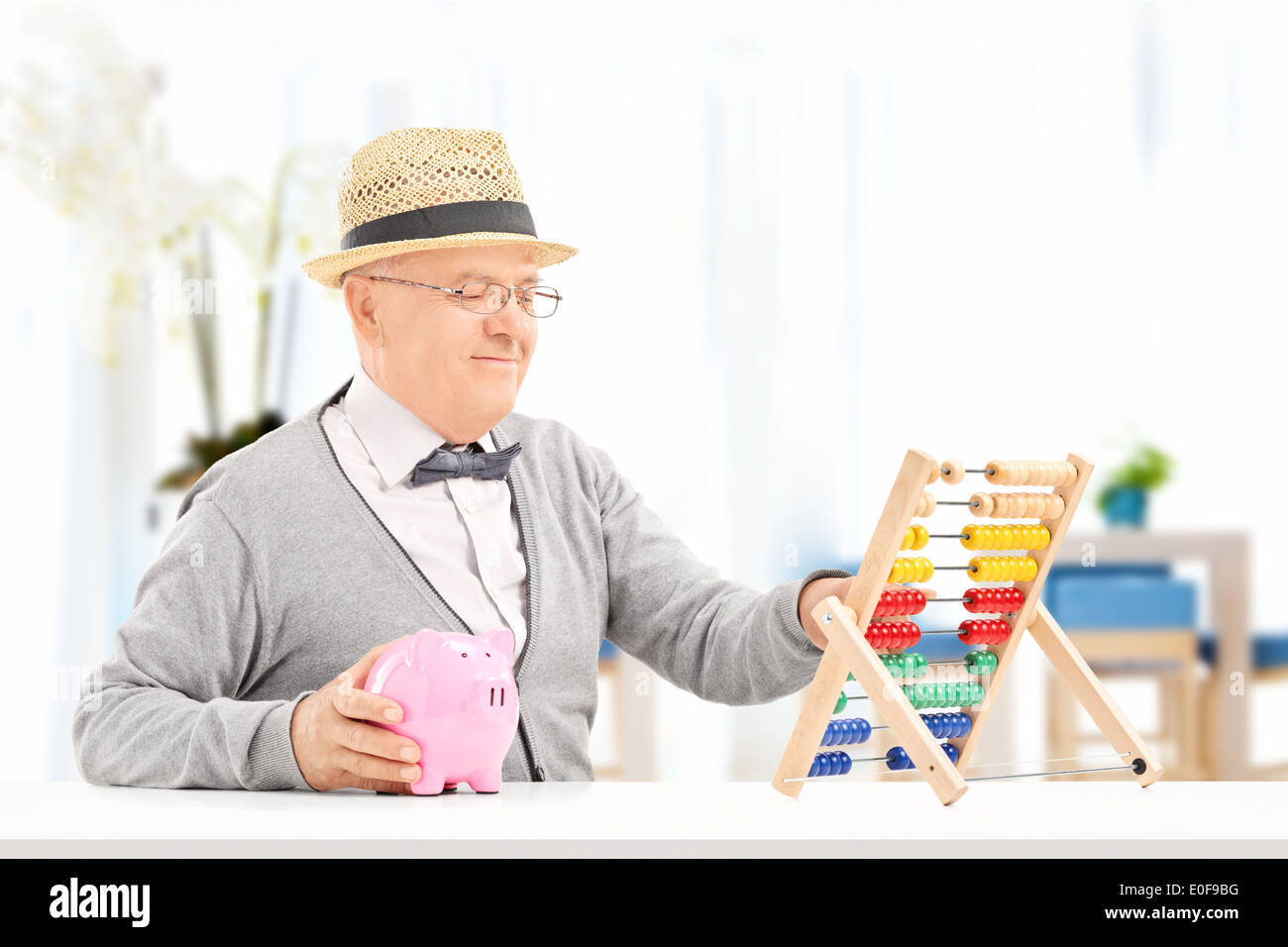 Senior a contare i suoi risparmi con abacus in ambienti interni Foto Stock