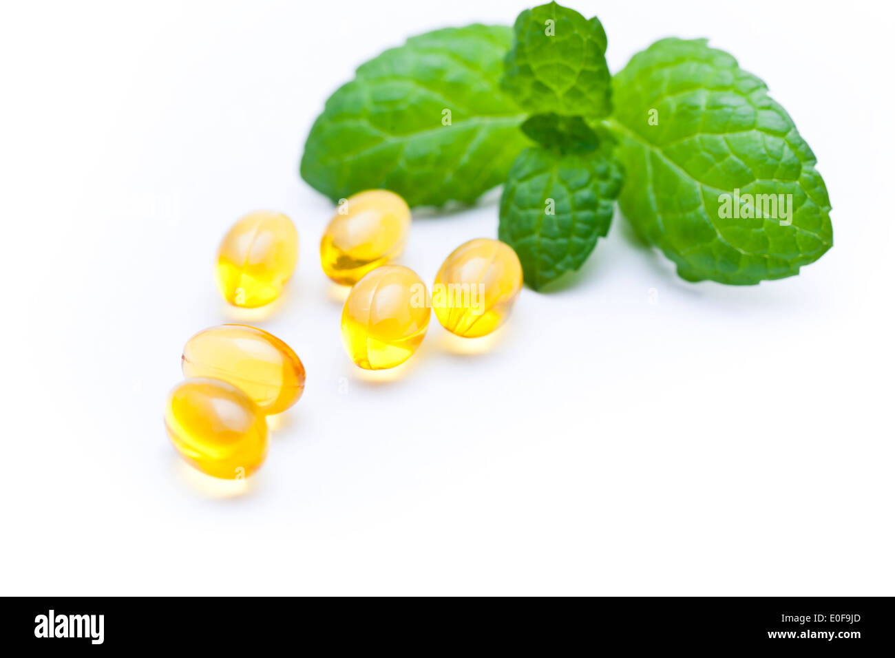 Gel vitamina capsule con una foglia di menta. . Foto Stock