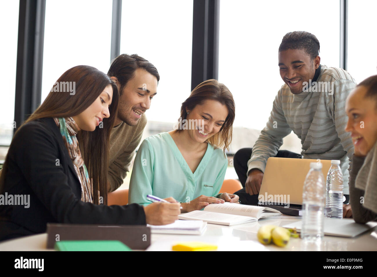 Gruppo di multirazziale giovani studenti studiando insieme a una tabella. Razza mista di persone facendo gruppo di studio. Foto Stock