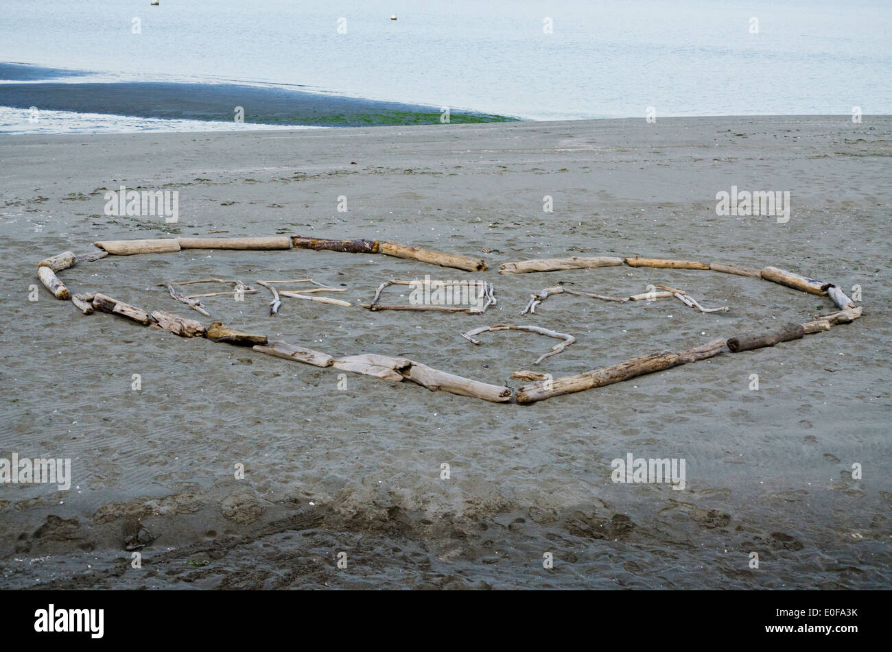 Romantico cuore prom proposta fatta con driftwood. Avvistato sulla spiaggia sulla Whidbey Island, nello Stato di Washington, U.S.A. Maggio 2014. Foto Stock