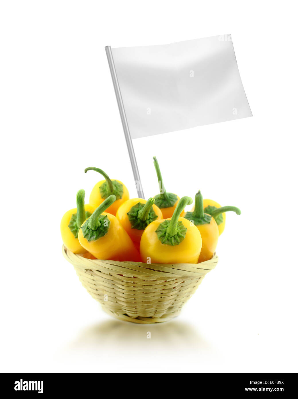 Sana e cibo organico concetto. Giallo fresco peperoncino in piatto di paglia con bandiera che mostra i vantaggi o il prezzo dei frutti. Foto Stock