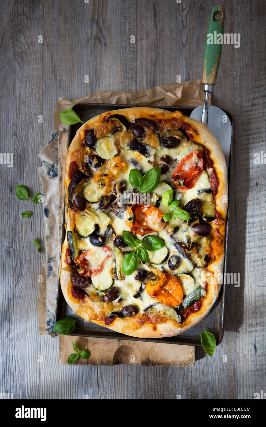 In casa di Verdure arrosto Pizza con olive, basilico e peperoni Foto Stock